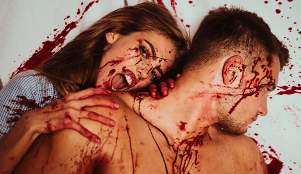 Sexy woman vampire bites mans neck. Meatman in butcher shop. Butcher cutting meat. Bloody make up