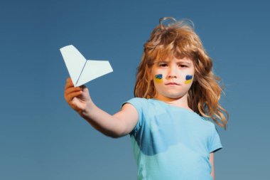 Gökyüzünü Ukrayna bayrağının üzerine kapatın. Ukrayna üzerinde uçuş bölgesi yok. Çocukların yanağında Ukrayna bayrağı