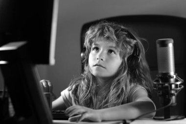 Geceleri bilgisayar kullanan bir çocuk. Karanlık bir odada bilgisayarı olan bir çocuk. Okul, eğitim, online öğrenme konsepti. Klavyede yazan öğrenci.