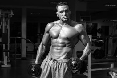 Spor salonunda halterli vücut geliştirici eğitimi. Çıplak gövdeli bir sporcu. Sportif egzersiz. Atletik vücut