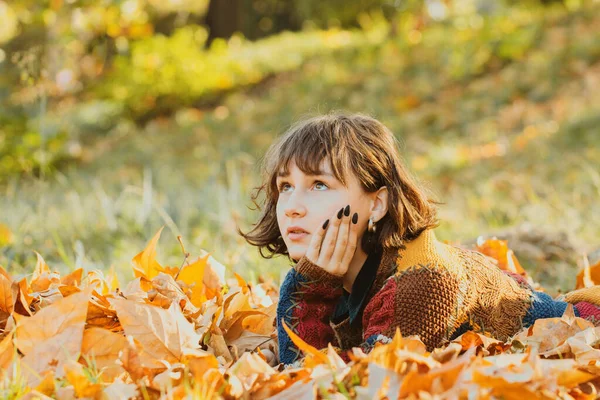 갈색의 머리를 여성이 쓰러진 오렌지 나뭇잎으로 뒤덮여 있습니다 마법의 아름다운 — 스톡 사진
