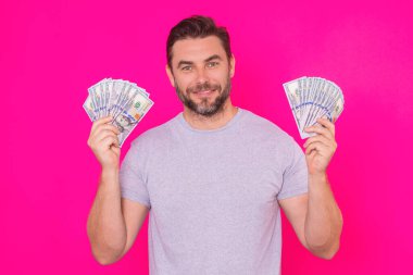 Çekici bir iş adamı para sayıyor. 100 dolarlık banknotlar tutan yakışıklı orta yaşlı bir adam. Parası olan başarılı bir iş adamı. Kâr ve finansal başarı. Dolar nakiti olan zengin bir adam.