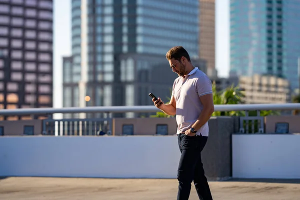 Man chatting on phone on the street. Handsome confident man talking on phone outside. Business phone conversation. Fashion man using phone in the street background in American city