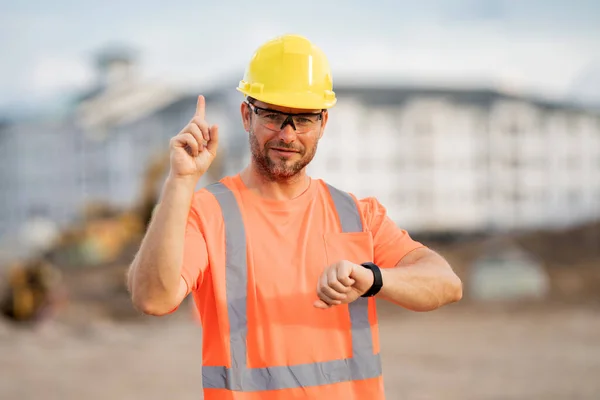 建筑背景上穿着制服的建筑工人 建筑工地的建筑商 建筑工地上戴头盔的男工 戴硬礼帽的硬汉 — 图库照片