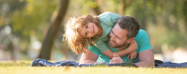 Dad and child boy hugging piggyback ride, spring banner. Childhood and parenthood kids concept. Happy father and son playing together outdoor