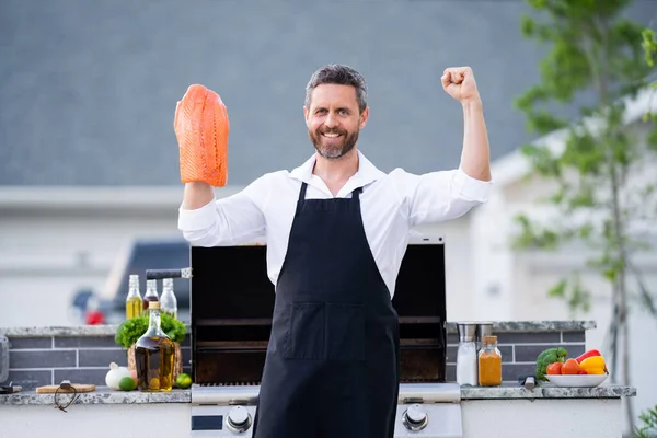 Kook Man Chef Schort Houd Zalm Vis Vast Een Barbecue — Stockfoto