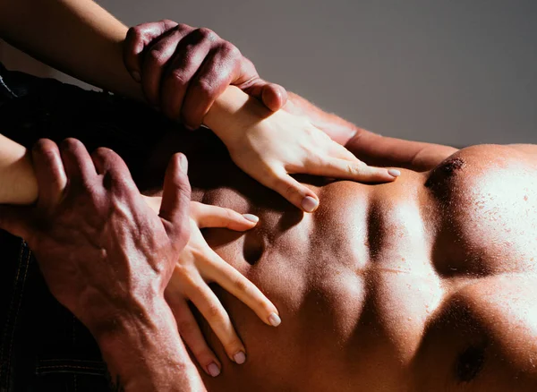 裸身でセクシーな筋肉裸の男と女の手 女はセクシーな男の胴に手を 女性の手は裸の筋肉質の胴を持つ男を受け入れる 男性の体に女性の手 — ストック写真