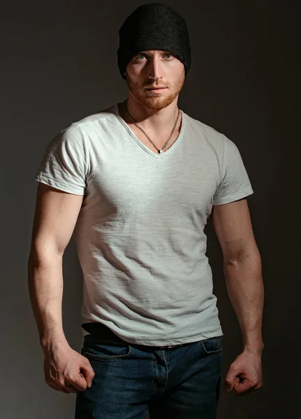 Man style and fashion. Brutal masculine man close up studio portrait. Handsome man with ginger red hair. Sexy ginger unshaven brutal man wearing beanie cap and white t-shirt