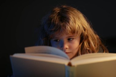 Çocuk yatakta sihirli bir kitap okuyor. Çocuk evde kitap okurdu. Yatmadan önce masal masalı
