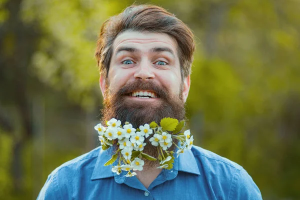 有趣的花胡子 阳光灿烂的日子里 留着胡子 身穿浅色衣服的男人站在开花的树旁看着相机 — 图库照片