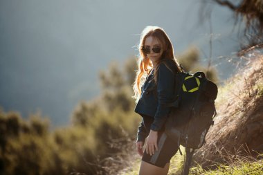 Sırt çantalı kız yürüyüşçü. Sırt çantasıyla dağlarda yürüyüş yapan bir kadın. Turizm konsepti turizm arka planı