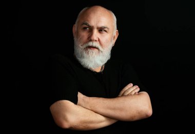 Ciddi bir kıdemli. Siyah arka planda olgun bir adamın portresi