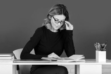 Boş bir karatahtanın üzerinde not defteri olan genç öğretmen ya da kız öğrenci. Bayan öğretmen eğitmeni.