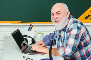 Sınıfta olgun bir öğretmen. Öğrencilerin en iyi öğretmeni. Öğretmenim. Çalışma ve bilgi günü konsepti