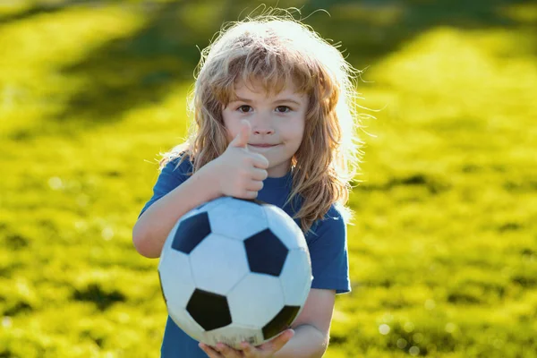 stock image Boy holding soccer ball, close up sporty kids portrait. Soccer boy show thumbs up success sign , child play football