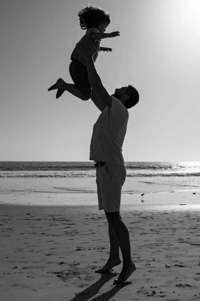 父は息子を青空に向かって投げ出す 父は子供を投げ 日没のシルエット フレンドリーな家族と夏休みの概念 — ストック写真