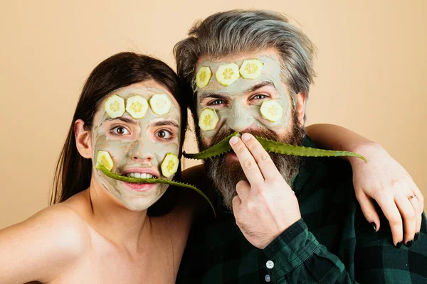 Guy with woman make mask for skin together, funny couple of lovers, isolated photo emotional. Funny couple with facial masks. Friends has fun with a facial mask with Cucumber and aloe vera having fun