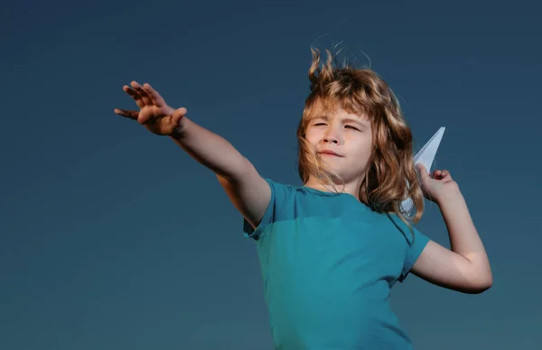 青い空の背景を持つ紙飛行機を投げる子供の男の子 — ストック写真