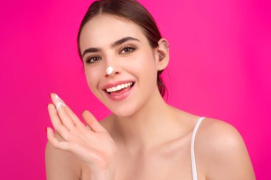 Yüz kremi süren güzel bir kadının güzel portresi. Nemlendirici cilt kremi, losyon ya da maske süren kadın cilt kaldırma ve yaşlanma karşıtı etki, stüdyo geçmişi