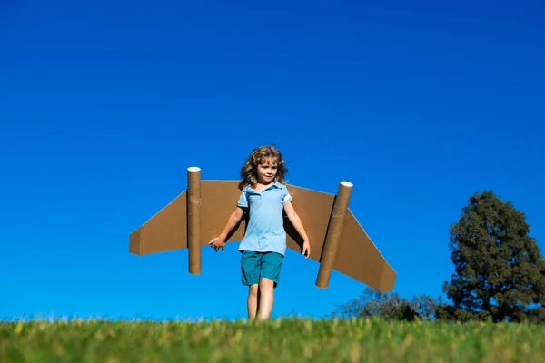 子供の男の子の想像力 小さなパイロットの夢とジェットパックの翼で飛ぶ おもちゃのジェットパックで遊ぶ幸せな子供 緑の芝生の屋外で楽しんでいる子供のパイロット 子供の革新とリーダーの概念 — ストック写真