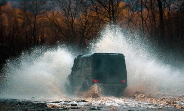 Yoldan çıktı. Açık havada nehirde SUV sıçraması, yolda seyahat. off-road yarışçamur sıçrama sıyrık cene. Yüksek hızlı deklanşörle eylemi durdurun