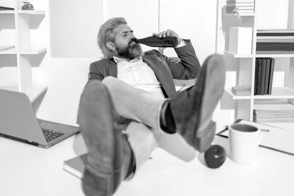 Businessman drinking beer in office, wide angle. Business man break for relax. Funny worker. Fun office worker going crazy of alcohol. Drunk addicted business manager getting up sitting in chair