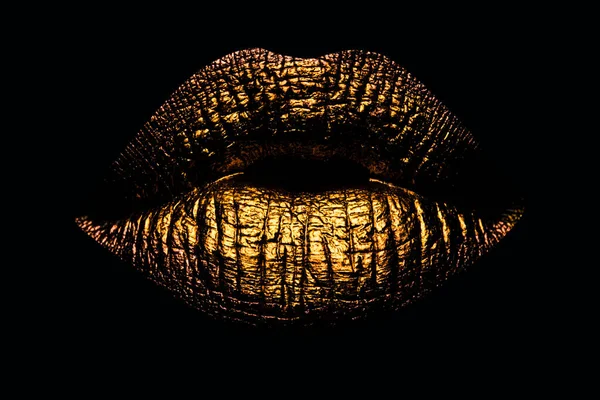 Abstract gold lips. Golden lips closeup. Gold metal art lip. Beautiful makeup. Golden lip gloss on beauty female mouth, closeup. Mouth Icon