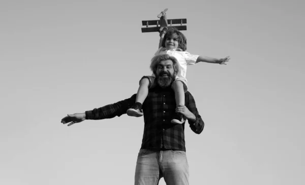 父と息子 父の日だ 父は息子を連れ戻す 父親の肖像画息子の肩に乗ってピギーバックを与えると検索します かわいいです男の子とともにお父さん遊びで木製飛行機屋外 — ストック写真