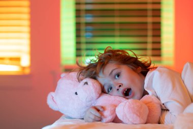 Yatakta korkmuş bir çocuk. Küçük çocuğun yatakta uyuduğu gece. Çocuk yatak odasında uyumaya gitti. Çocuk karanlıktan korkar. Çocuklarda kabuslar ve korkunç rüyalar