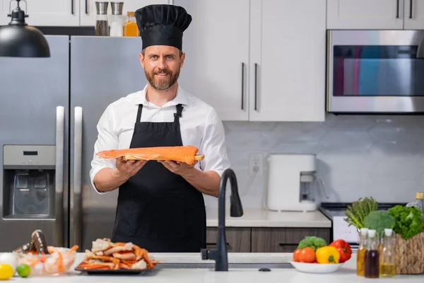 Millennial Uomo Ispanico Grembiule Chef Cuoco Cappello Tenere Filetto Salmone — Foto Stock