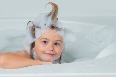 Çocuk köpük banyosu yapıyor. Küçük çocuk sabun köpüğüyle banyo yapıyor. Komik çocuk suratı