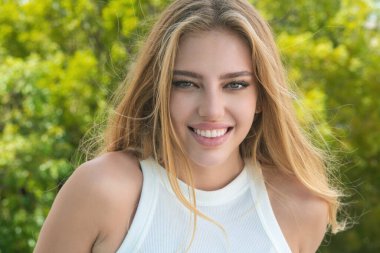 Doğal makyajlı ve kusursuz temiz tenli genç bir kadının moda portresi. Yazın dışarıda poz veren seksi bir model. Moda saç stili olan bir kız. Güzel kadın yüzü. Yakından.