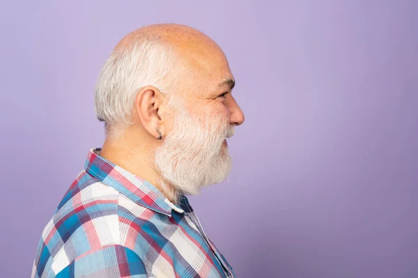 Profile of old mature senior man with grey beard on black studio background. Older grandfather, grandpa pensioner, retiree concept
