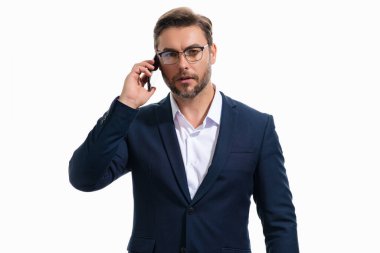 İş adamı takım elbiseli akıllı telefon kullanıyor. Portre çekici, neşeli adam telefonu kullanıyor, cep telefonundan arıyor. Akıllı telefon kullanan yakışıklı iş adamı, izole edilmiş stüdyoda sohbet ediyor.