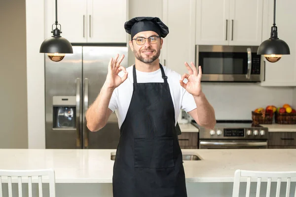 シェフの料理には おいしい料理があります レストランメニューのコンセプト パン屋の制服を着たヒスパニック系の男 料理と料理 黒エプロン シェフの帽子で働く男性シェフ — ストック写真