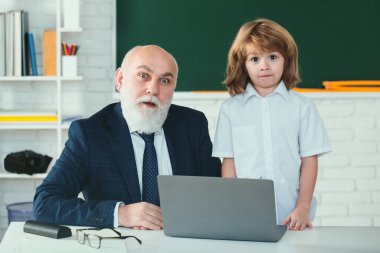 Kıdemli öğretmen ve çocuk öğrenci sınıfta. Eğitim konsepti. Okul öğrenme konsepti. Erkek ilkokulu