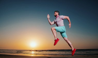 Atletik genç adam koşuyor. Sağlıklı yaşam tarzı kavramı. Dinamik atlama hareketi. Spor ve sağlıklı yaşam tarzı