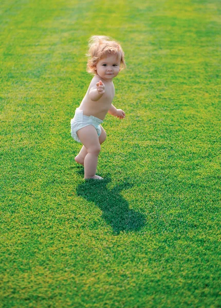 有趣的是 笑着的宝宝穿着尿布学习爬行 在草坪上玩耍 观看夏天的花园 第一步 — 图库照片