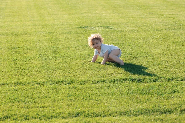 かわいい面白い赤ちゃんの男の子は 庭の芝生で遊んで楽しんで 一歩を這うことを学ぶ 公園内の暖かい春の時間 — ストック写真