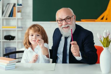 Okuldaki mutlu çocuk. Öğretmenin öğrenmesine yardım et. Eğitim, öğretmenlik, ilkokul