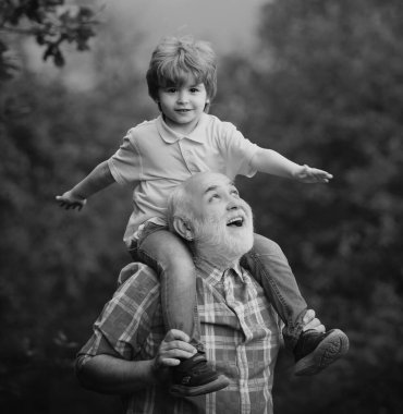 Büyükbaba ve torunu dışarıda oynuyorlar. Aile tatili ve birliktelik. Nesil. Büyükbaba ve torun parkta.
