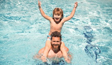 Baba oğul havuzda. Yaz haftasonu. Havuz partisi. Babası yüzme havuzunda oynayan bir çocuk.