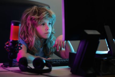 Bilgisayar ekranındaki küçük çocuk. Sevimli anaokulu çocuğu uyumadan önce masaüstü film izliyor. Aletlerin aşırı kullanımı ve bağımlılığı. Çocuklar için sosyal ağ