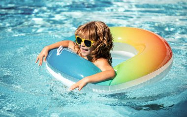 Yaz tatili. Yaz çocukları hafta sonu. Aquapark 'ta şişme lastik çemberde yüzen komik çocuk.