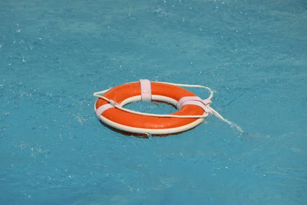 泳ぎはしない 水救助緊急機器 救助リング澄んだプールの水に浮かんでいます — ストック写真