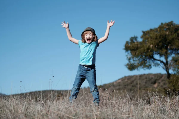 Happiness, childhood, freedom, movement and people concept - happy smiling boy jumping