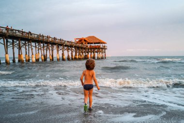 Denizde oynayan mutlu çocuk. Yaz tatili ve tatil konsepti
