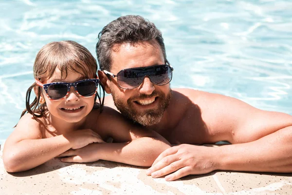 Father and son in pool. Vacation concept. Happy family in swimming pool. Pool party. Child with dad. Fathers Day