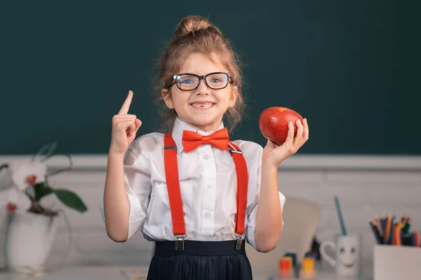 학교에 다니는 여학생을 손가락으로 칠판을 가리키는 놀라운 표정을 학교에서의 — 스톡 사진