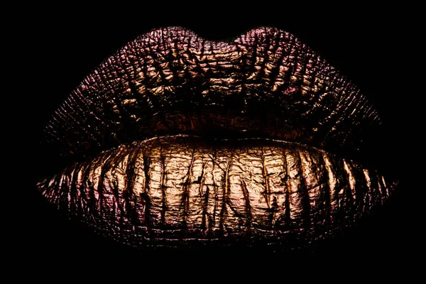 Abstract gold lips. Golden lips closeup. Gold metal lip. Beautiful makeup. Golden lip gloss on beauty female mouth, closeup. Mouth Icon
